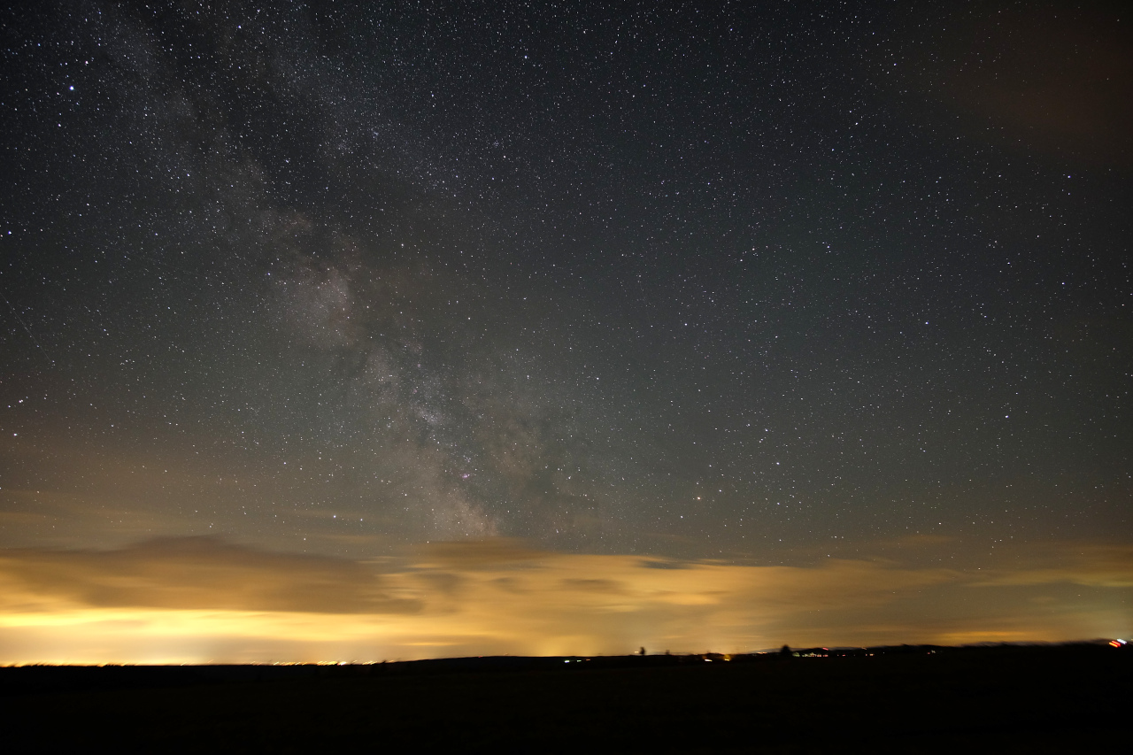 Nerovný souboj. Vrstva oblačnosti odděluje Mléčná dráhu od světla měst a vesnic pod ní. Manětínská oblast tmavé oblohy. Foto: Michal Bareš